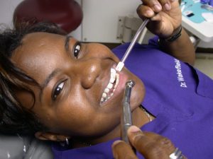 Dr Candy, smiling and getting a teeth cleaning