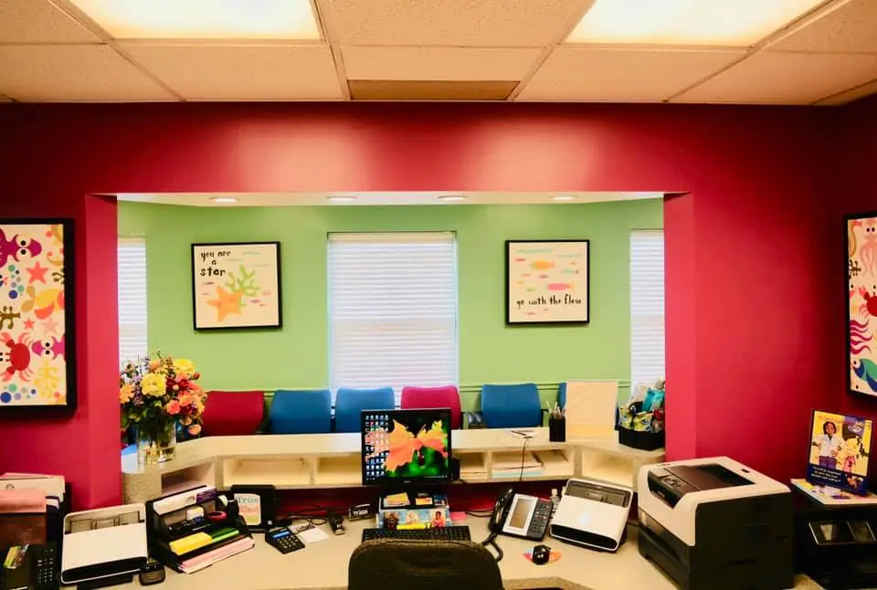 Organized pediatric dental reception desk, looking out into a colorful and clean waiting room in Florissant MO