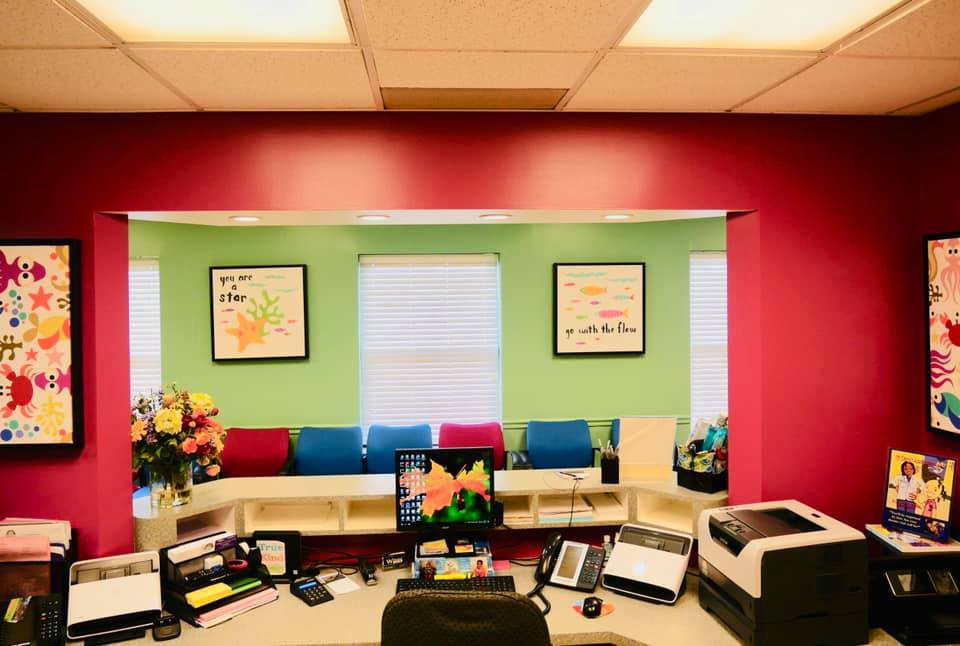 Organized pediatric dental reception desk, looking out into a colorful and clean waiting room in Florissant MO